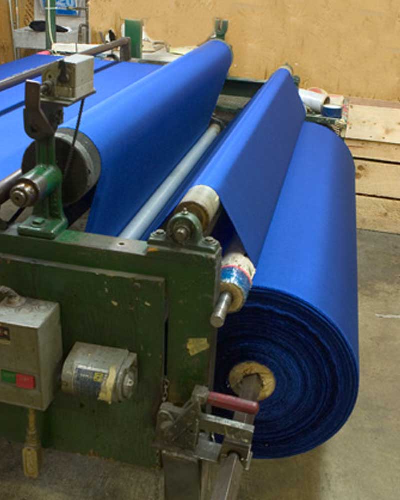 USFMA-Shipping-2 blue fabric on spools through a manufacturing machine