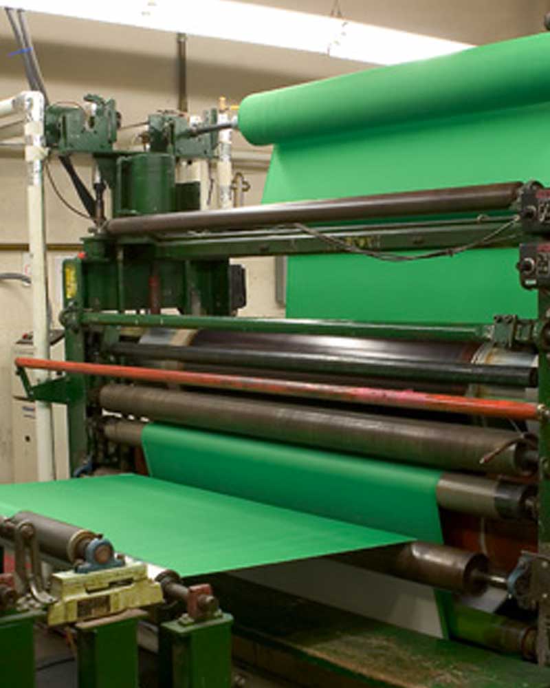 USFMA-Shipping-5 Green fabric going through rollers on a manufacturing machine